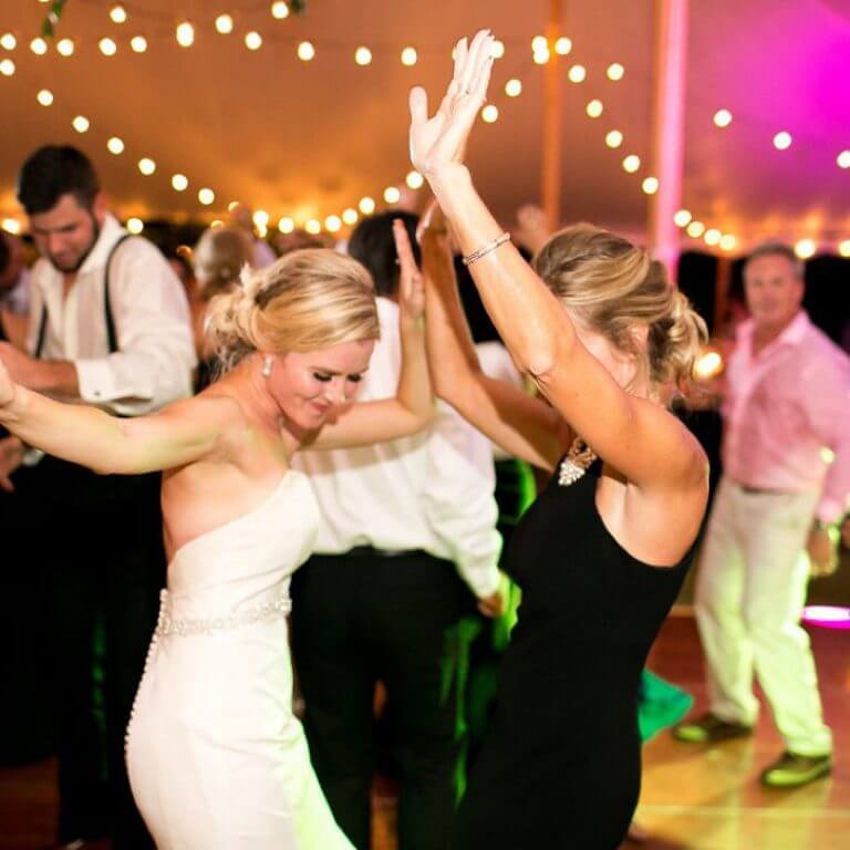 Happy bride dancing at her wedding reception hosted by band None Other